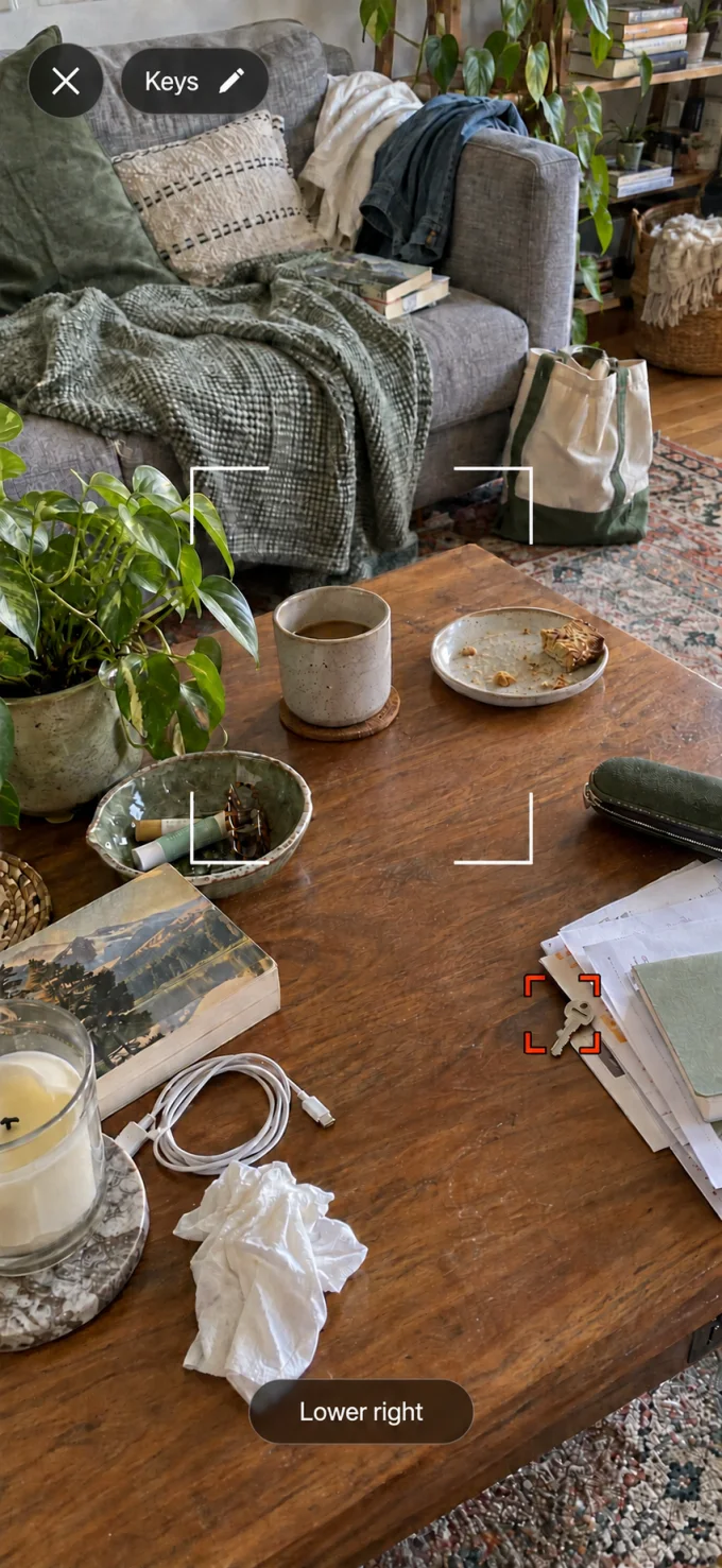 Findlet camera preview highlighting keys near the lower-right corner of a cluttered coffee table.
